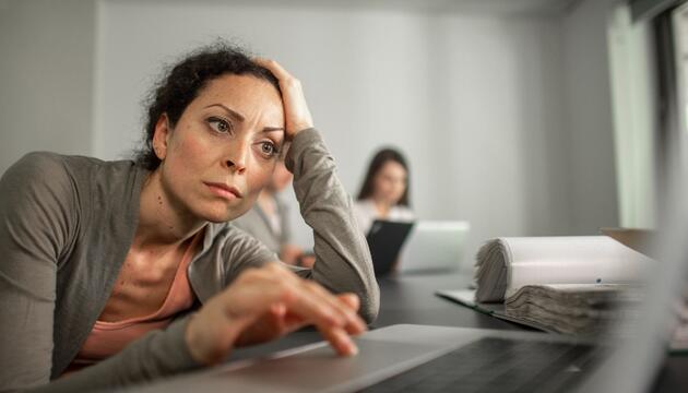 Frau sitzt frustriert vor einem Laptop