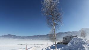 Wintercamper mit Wohnmobil auf einem Campingplatz