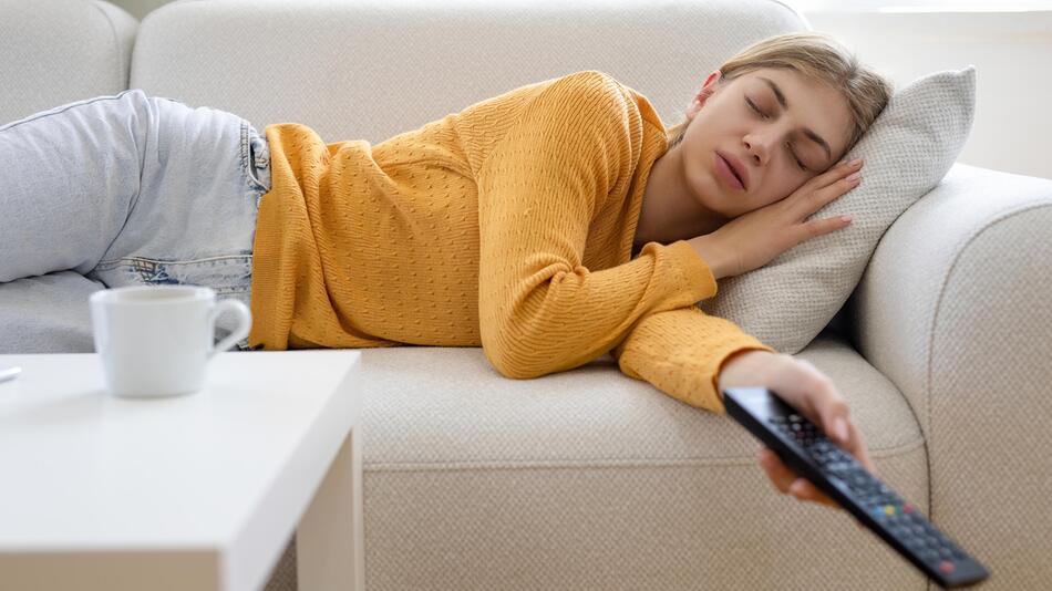 Frau schläft vor dem Fernseher