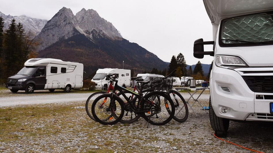 Camper stehen vor einer Bergkulisse