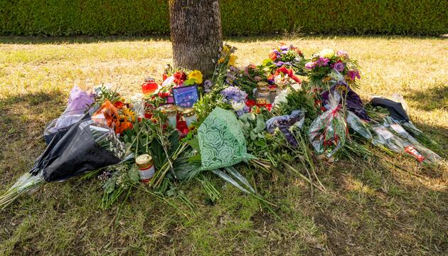 Baum in Ingolstadt, viele Blumen und Grablichter darunter.