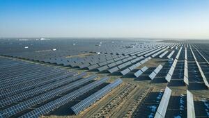 Grosses Solarkraftwerk mit unzähligen Solarpanelen, die in Reihen auf einer kargen, leicht ...