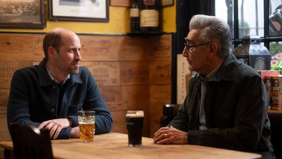 "Urlaub wider Willen mit Eugene Levy": Prinz William und Eugene Levy unterhalten sich in einem Pub.