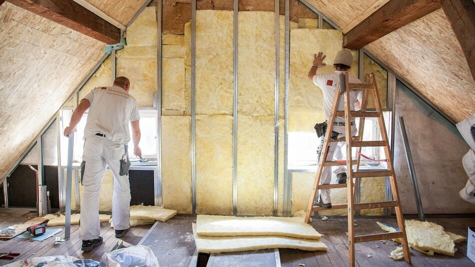 Zwei Handwerker dämmen ein Dachgeschoss