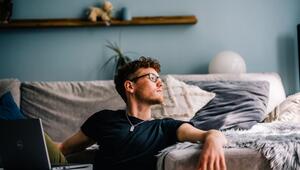 Ein junger Mann sitzt auf dem Boden vor seinem Computer