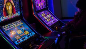 Eine Person sitzt an einem Spielautomaten