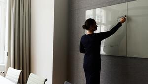 Eine Frau steht in einem Konferenzraum an einem Whiteboard