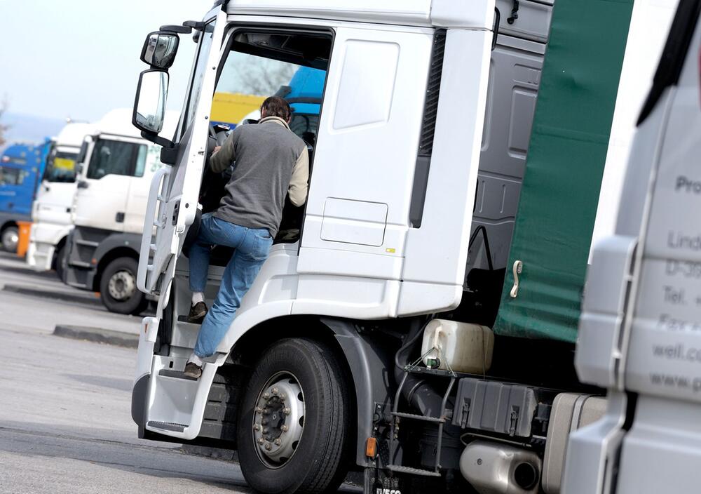 Ein Fernfahrer steigt in seinen LKW