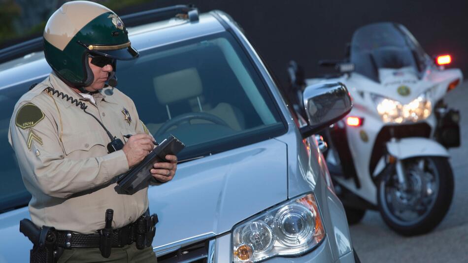 Ein amerikanischer Polizist kontrolliert ein Auto.