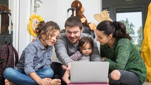 Eine Familie sitzt vor dem Laptop und bucht eine Reise