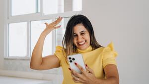 Frau schaut auf ihr Handy und freut sich 