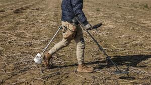 Schatzsucher geht mit einem Metalldetektor über ein Feld