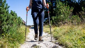 Eine Wanderin unterwegs mit Wanderstöcken