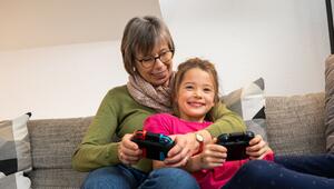 Eine Oma und ihre Enkelin spielen zusammen Videospiele