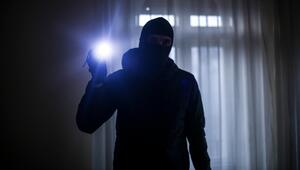 Einbrecher mit Taschenlampe im Inneren einer Wohnung