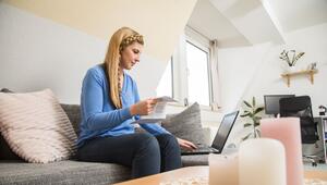 Frau sitzt mit einer Abrechnung vor einem Laptop
