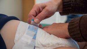 Eine Frau wechselt die Windeln ihres Kindes
