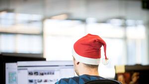 Ein Mann sitzt mit einer Weihnachtsmütze in Büro