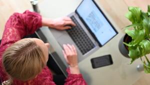 Eine Frau sitzt zuhause an einem Laptop