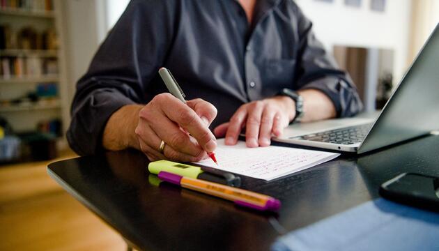 Mann arbeitet im Homeoffice an seinem Schreibtisch