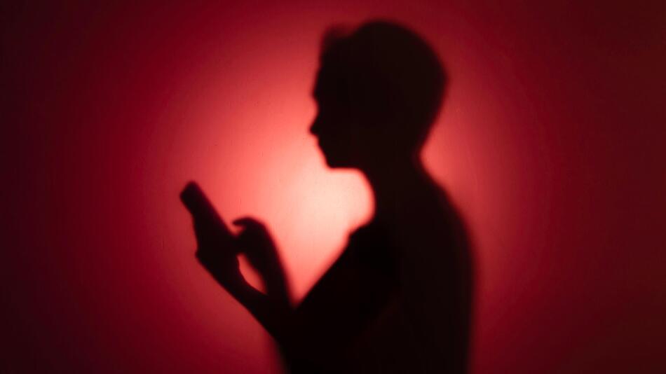Die Silouette einer Frau mit Smartphone