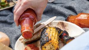 Frau gibt Grillsauce auf einen Teller
