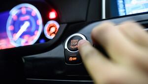 Ein Mann drückt den Start-Stop-Knopf eines Keyless-Go-Autos