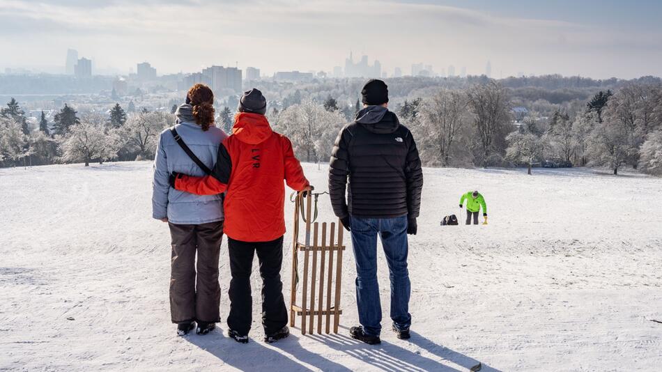 Eine Familie steht mit ihrem Schlitten auf dem Lohrberg