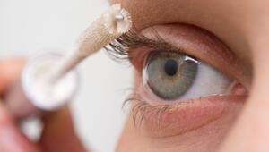 Eine Frau tuscht  ihre Wimpern mit Wimpernserum