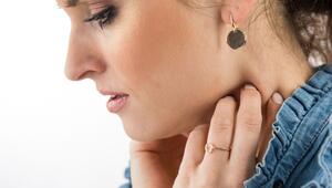 Frau fasst sich an den Hals