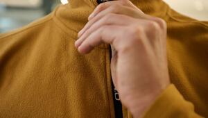 Ein Mann schliesst den Reissverschluss einer Fleecejacke