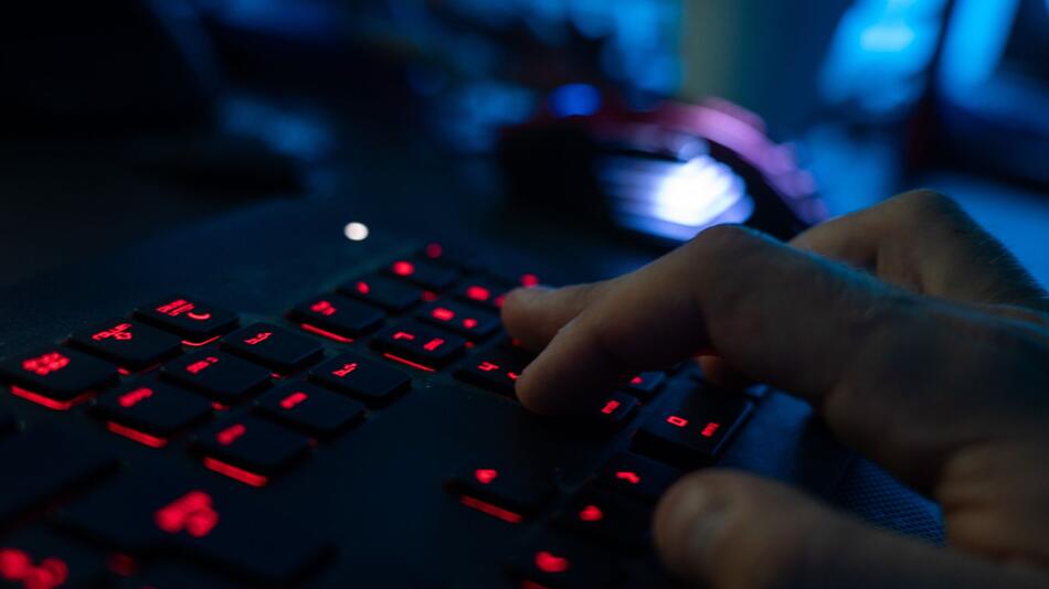 Mann tippt auf einer Tastatur