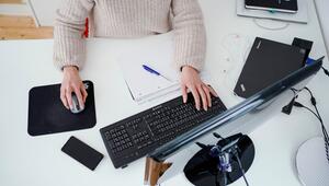 Eine Person arbeitet im Homeoffice an einem Schreibtisch