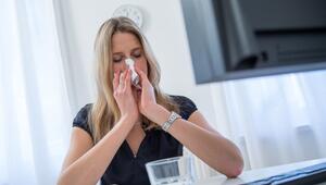 Frau sitzt erkältet vor ihrem Rechner zu Hause