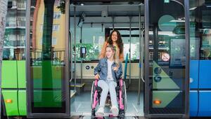 Begleitperson schiebt Rollstuhlfahrerin aus einem Bus