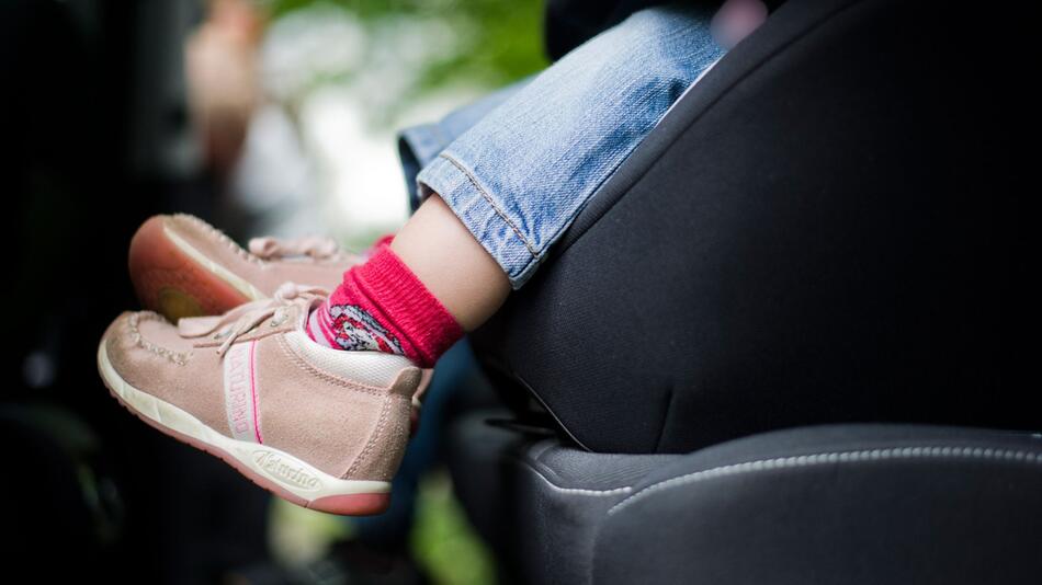 Mädchen sitzt in einem Kindersitz im Auto