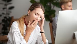 Junge Frau am Computer, die gähnen muss
