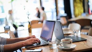 Ein Mensch arbeitet an seinem Computer in einem Café