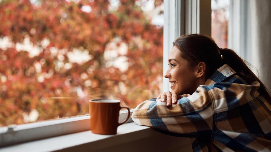 Eine Frau guckt aus dem Fenster