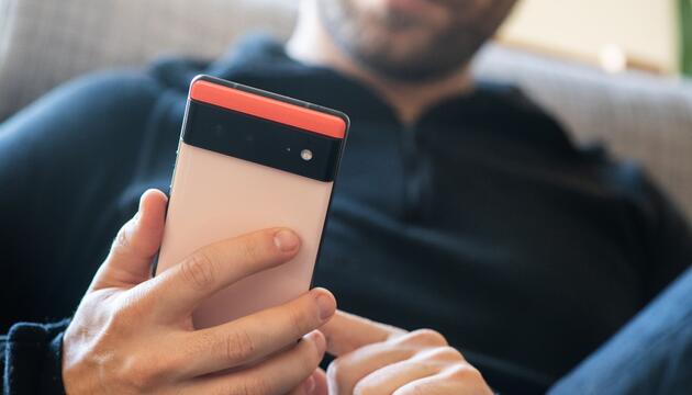 Ein Mann hält ein Google Pixel 6 in den Händen
