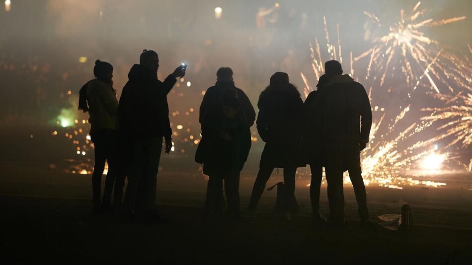 Gruppe von Menschen entzündet Feuerwerksraketen