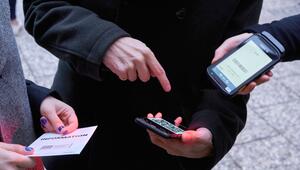 Ein Mann zeigt auf einen QR-Code den eine Frau Scannt