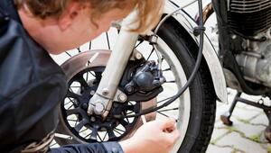 Mann kontrolliert die Reifen an seinem Motorrad