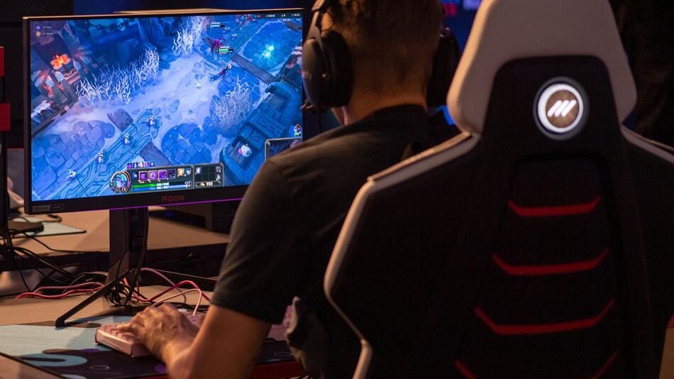 Messebesucher spielt ein Computerspiel während der Gamescom