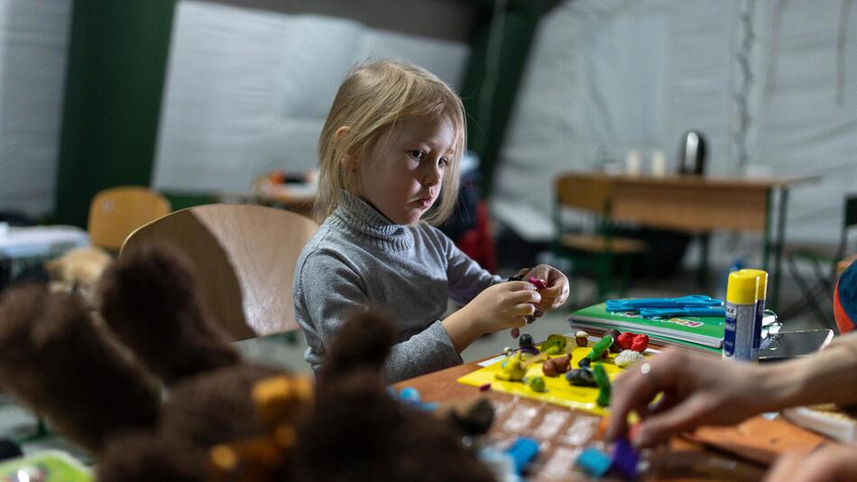 Ein Mädchen spielt in einem beheizten Zelt