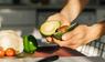 Zwei Hände halten eine aufgeschnittene Avocado.