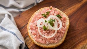 Mettbrötchen liegt auf einem Holzbrett