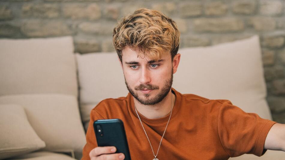 Mann schaut auf ein Smartphone
