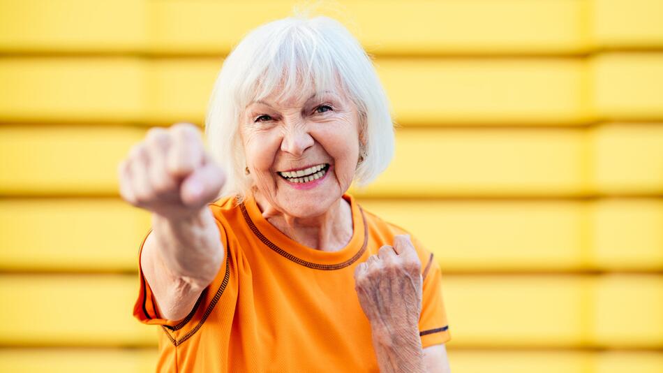 Seniorin lacht in die Kamera und macht einen sportlichen Eindruck