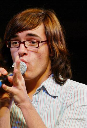 Daniel Küblböck singt in ein Mikrofon. Er trägt ein helles Streifenhemd.